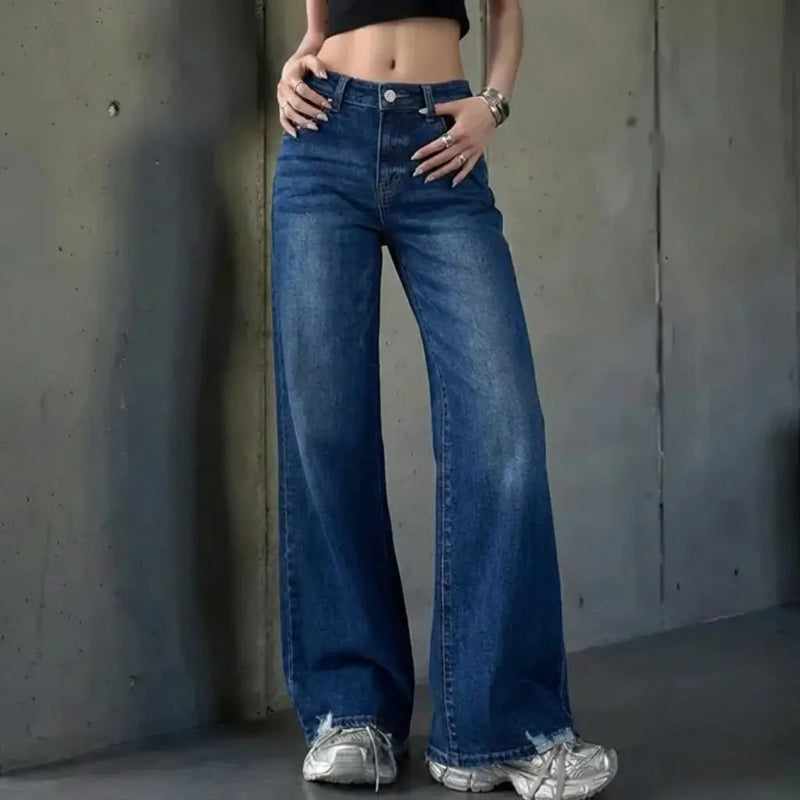 Sassy Model wearing a denim jean standing in front of a concrete wall